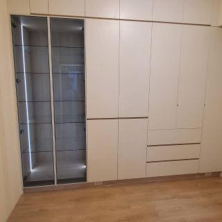 淇淇世界花園室內設計案例：大容量純白系統衣櫃整合精品玻璃展示櫃，內嵌線型感應燈條增加質感。