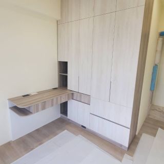 富霖映樂室內設計案例：臥室整合式系統衣櫃與 L 型書桌規劃，淺木紋配色放大室內視覺感。