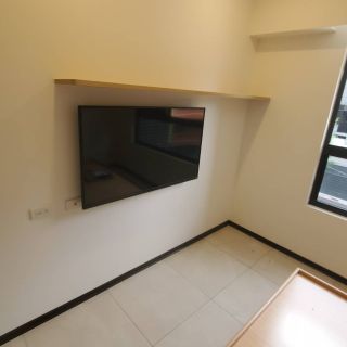 捷市邦臥室裝修實績：壁掛式電視牆搭配極簡木質長層板，小坪數空間的高效利用。