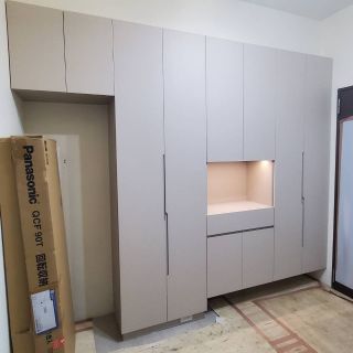 品橙沙鹿案玄關設計：頂天立地式系統鞋櫃與置物櫃，內嵌展示區搭配氛圍照明感應燈。