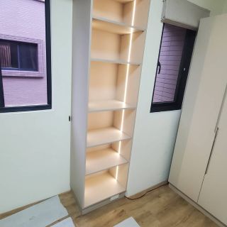 品橙沙鹿案展示櫃：垂直式開放收納櫃，內嵌側邊 LED 燈條營造如精品櫃般的展示效果。