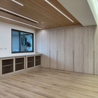 惠宇敦品全屋裝修：頂天立地式木紋系統收納牆，搭配窗邊長型矮櫃與天花板線性照明美學。
