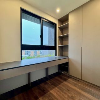 元城上階綠臥室家具配置：整合衣物儲藏與閱讀功能的系統家具，呈現一致性設計風格。