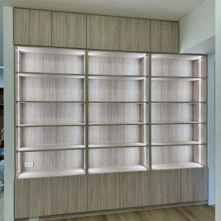惠宇敦品精品質感櫃體：客製化系統書櫃內嵌垂直 LED 燈條，提升展示物陳列層次感。