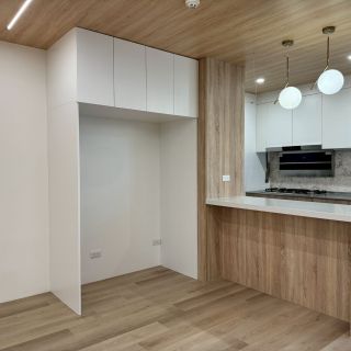 惠宇敦品廚房規劃：簡約白冰箱電器櫃整合木質中島吧檯，營造現代感十足的餐廚開放式空間。