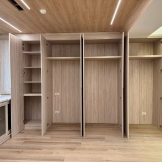 惠宇敦品系統櫃實績：臥室大容量木紋衣櫃開啟展示，包含吊衣桿與彈性分層收納規劃。