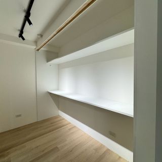 惠宇敦品多功能房設計：極簡長型白色層板桌與木質飾條導引視覺，優化閱讀空間機能。