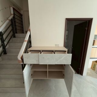 嘉義玄關收納規劃：懸空式石紋門片收納櫃，開啟展示其分類抽屜與鞋櫃儲物空間。