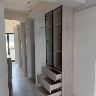 嘉義精品收納設計：黑框玻璃展示櫃與頂天立地系統衣櫃整合，內建線型燈營造高端氛圍。