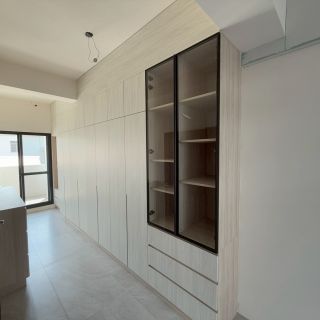 嘉義客製化家具：整面式淺色木紋系統櫃立面，結合衣櫃、展示區與閱讀空間的複合機能。