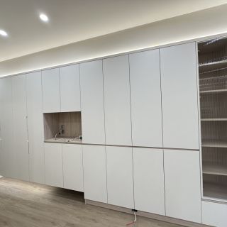 品橙勝美欣客廳電視牆細節：整合式系統牆面設計，採用白色門片搭配長虹玻璃展示格位。