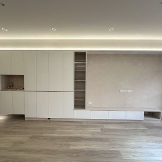 品橙勝美欣客廳裝潢實錄：大面積收納牆與展示玻璃櫃的對稱設計，展現精密的系統家具工程。