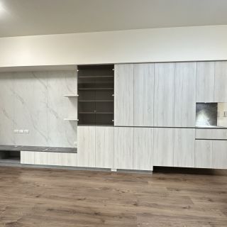 品橙馥景客廳設計：整面牆式系統櫃規劃，結合石紋電視牆與隱藏式多功能收納空間。