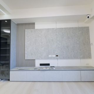 品橙綠雅圖客廳主牆規劃：平面化無把手櫃體設計，結合影音設備放置空間的高效收納。