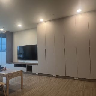 領袖特區室內設計案例：客廳整面式現代簡約系統櫃，淺灰色門片營造俐落視覺與強大收納量。