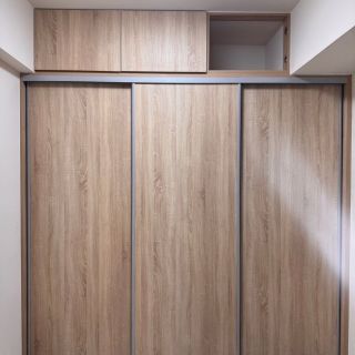 皇普江宅臥室設計：淺木紋滑軌門系統衣櫃搭配頂層儲物空間，提升居家收納坪效。