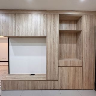 皇普江宅客廳收納牆規劃：一體化木紋系統櫃整合電視預留位與開放式展示架。